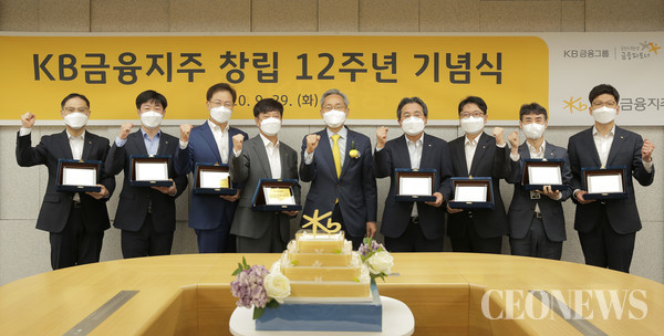 창립 12주년 기념식에서 장기근속 직원들과 기념사진을 촬영중인 (가운데)윤종규 회장