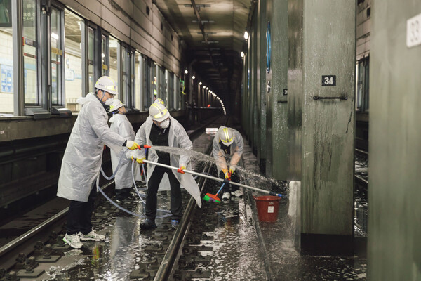 미세먼지 저감 대책의 하나로 직원들이 4호선 쌍문역 선로에서 물청소를 하고 있다(사진=서울교통공사)