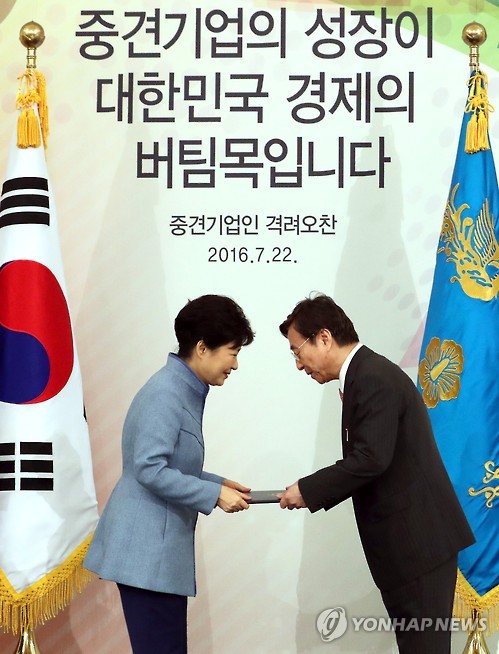 박정부 다이소아성산업 회장이 2016년 7월 22일 청와대에서 열린 중견기업인 격려오찬에서 박근혜 대통령으로부터 금탑산업훈장을 받고 있다. (사진=연합)